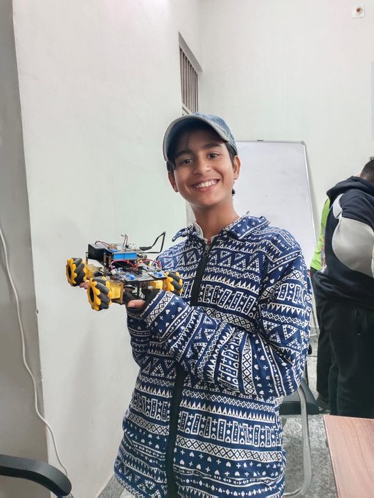 Tanvi Panwar holding a robotics car project